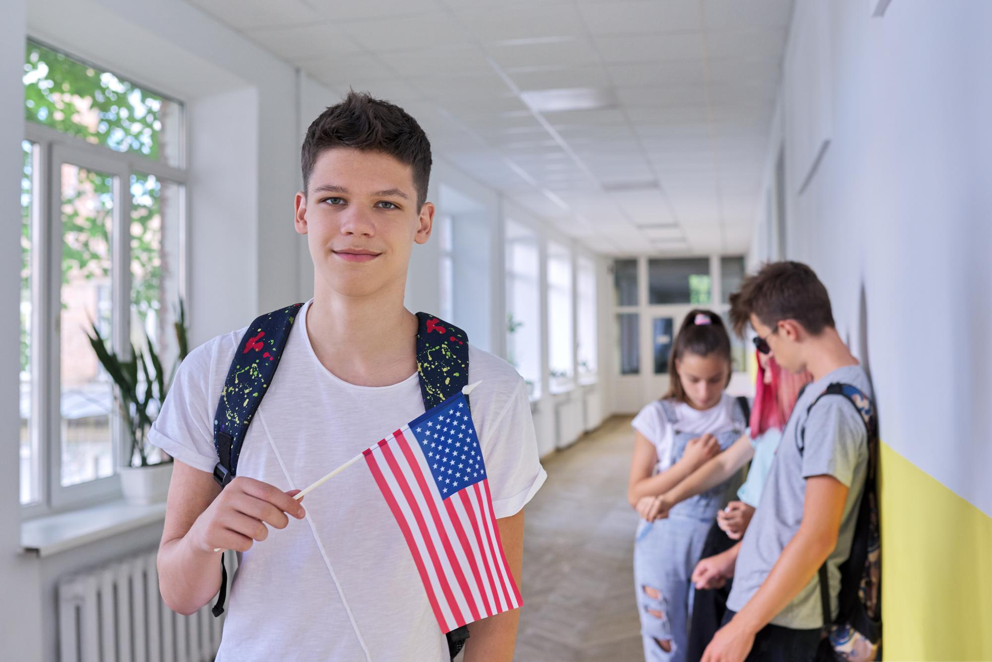 Chłopiec w szkole trzymający flagę Stanów Zjednoczonych